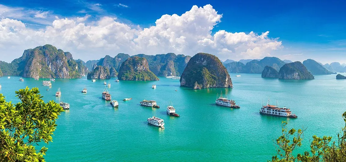 Kalksteininseln und Ausflugsschiffe in der Halong-Bucht